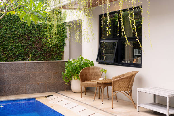 istock Cozy Outdoor Seating by the Pool with Lush Greenery 2200504316