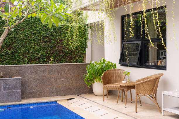 istock Cozy Outdoor Seating by the Pool with Lush Greenery 2200504401
