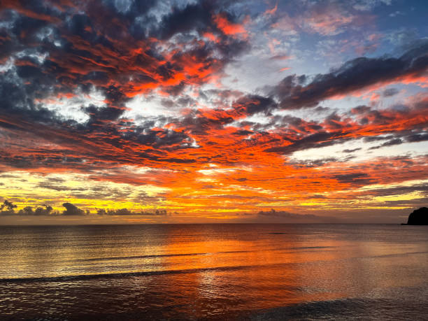 istock The tropical island sunset features intense colors across the sky, with dark clouds creating a dramatic contrast over the peaceful ocean 2200505439