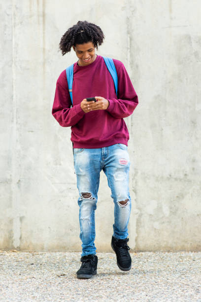 istock Happy black man using mobile phone outdoors in city 2200506016