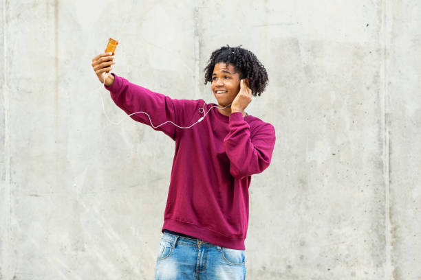 istock Man having fun using mobile phone and headphones outdoors 2200506025