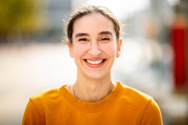 istock Smiling young woman standing outside 2200506435