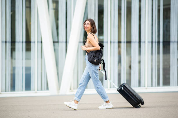 istock Young woman walking outdoors with luggage 2200506445