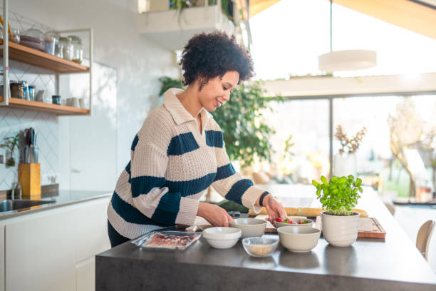 istock Smiling Multiracial Woman Preparing Ingredients in Modern Kitchen 2200506987