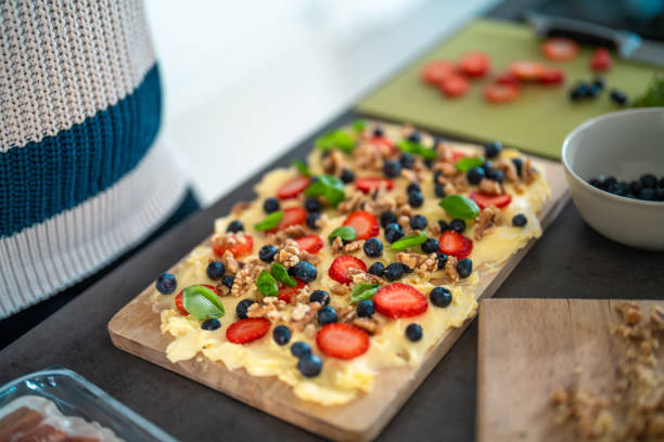 A vibrant butter board adorned with fresh strawberries, blueberries, and nuts, set on a kitchen counter. Perfect for a delightful and tasty gathering centerpiece.
