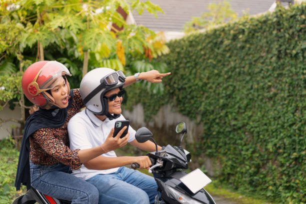 istock Happy Young Couple Riding a Scooter on a Rural Road 2200508671