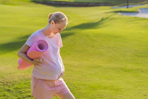 istock Energetic pregnant woman takes her workout outdoors, using an exercise mat for a refreshing and health-conscious outdoor exercise session 2200519659