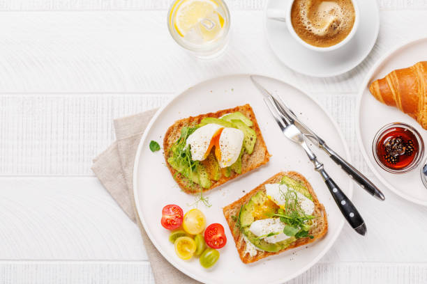 istock Breakfast with delicious avocado toasts and crispy croissant 2200520682