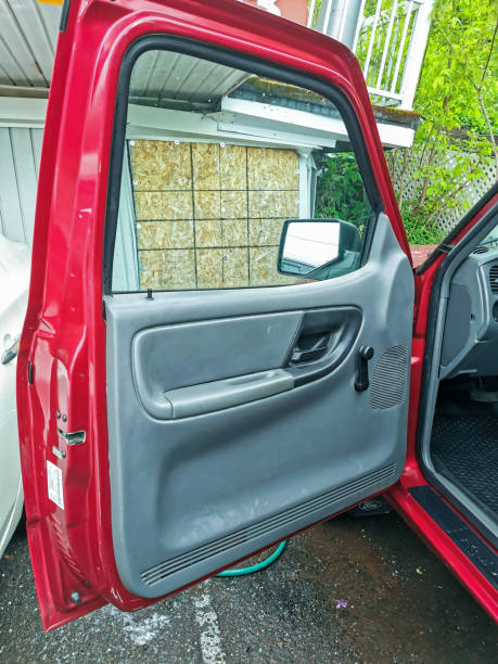 istock Open Red Pickup Truck Door Showing Interior Panel and Handle in a Parking Area 2200523302