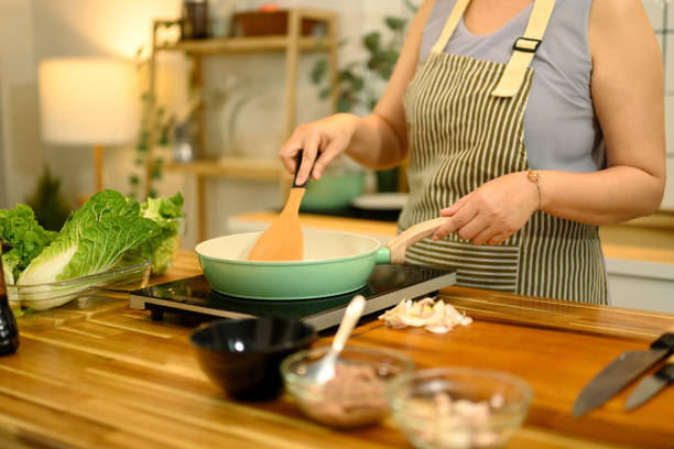 istock Middle aged woman preparing a healthy meal in the kitchen 2200526406