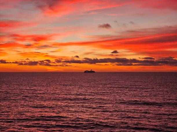 istock Vibrant sunset over ocean with ship silhouette. 2200526483