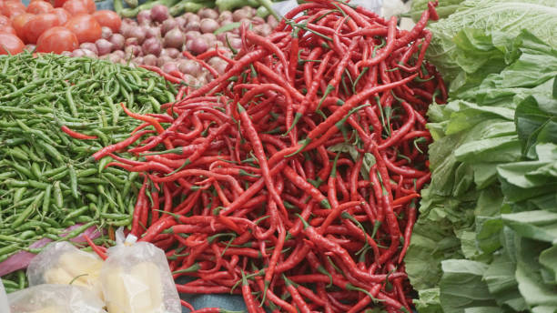 istock Red and Green Chili Peppers on Display at a Vegetable Stall 2200526632