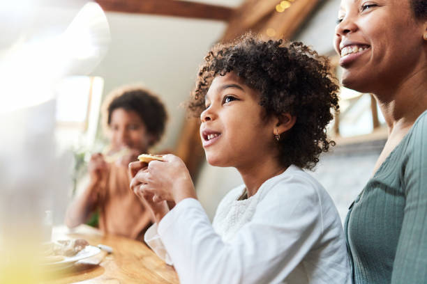 istock Cute black girl eating pancake at home. 2200528812