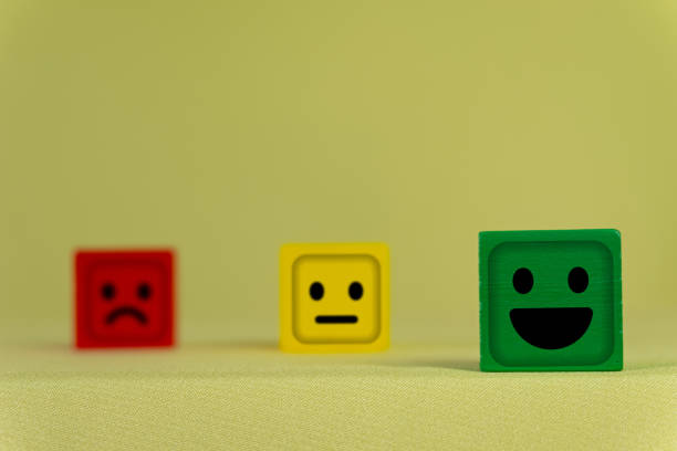 Green Wooden Cube with Smile Face Highlighted Among Red and Yellow Sad Face Cube concept for ,mental health, positive thinking, and emotional wellbeing theme,Customer review good feedback and satisfaction survey.
