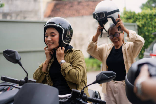 istock Muslim Women Putting on Helmets Before Riding Motorbikes 2200530485