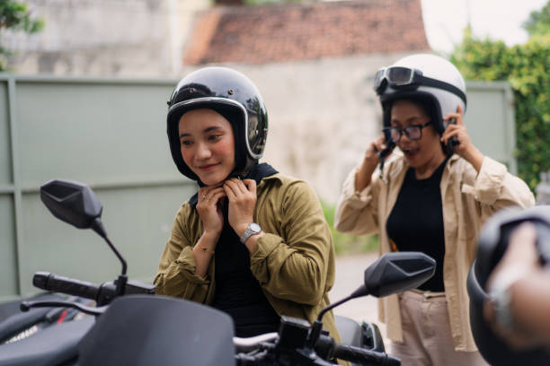 istock Muslim Women Putting on Helmets Before Riding Motorbikes 2200530601