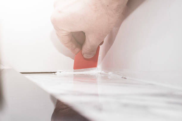 istock grouting joints with a plastic spatula on porcelain tiles with silicone grout, finishing of rooms for comfortable living 2200530944