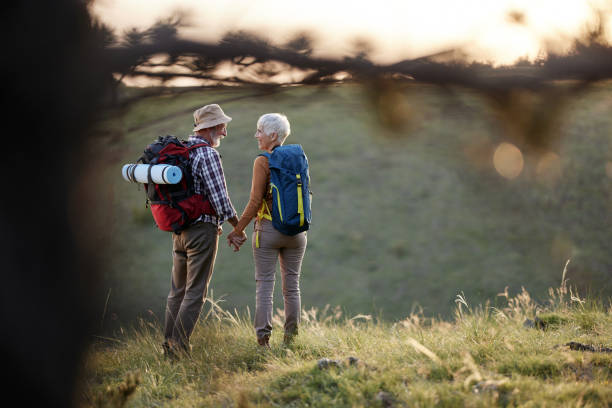 istock Back view of senior hikers talking on a hill. 2200531048
