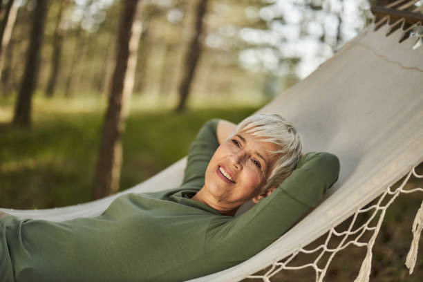 istock Happy senior woman day dreaming in hammock. 2200532435