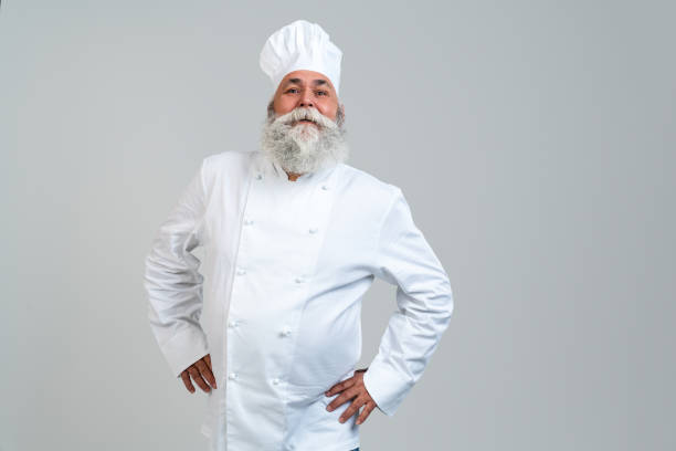 istock Senior old man cooking chef with gray beard portrait in studio 2200537268