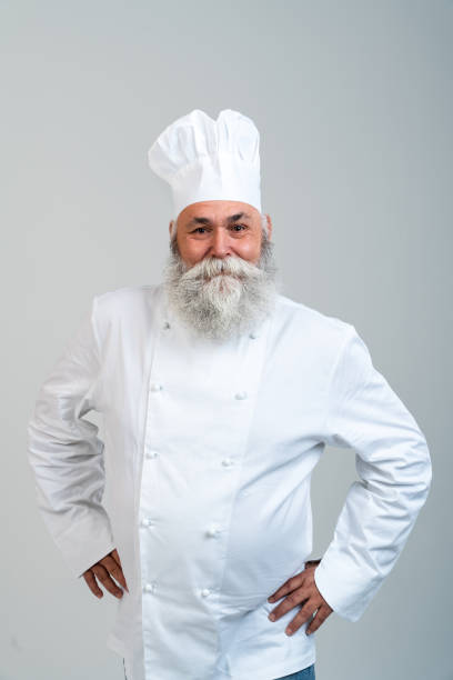 istock Senior old man cooking chef with gray beard portrait in studio 2200537467