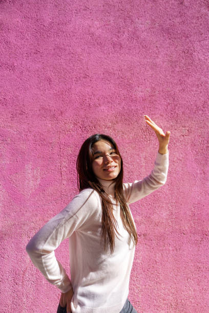 istock Young woman dancing with pink wall background 2200537874