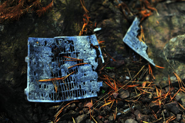 Closeup of scrap metal garbage from car battery on beach floor. Littering in nature.