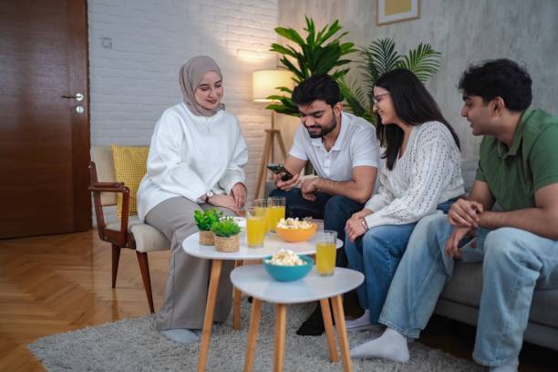 istock Friends watching something on smartphone and having snacks and drinks at home 2200538874