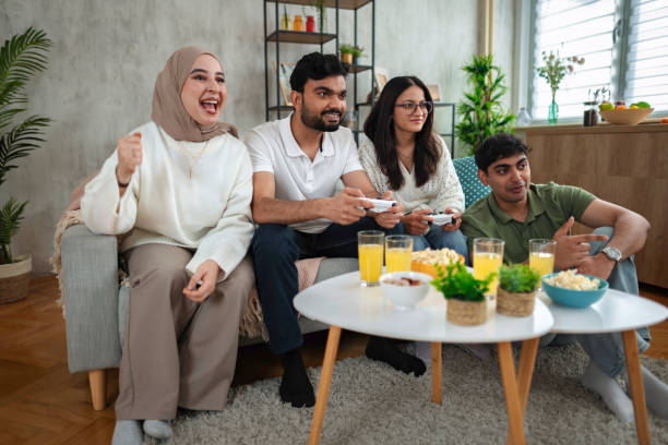 istock Four friends playing video games at home, having fun together 2200538892