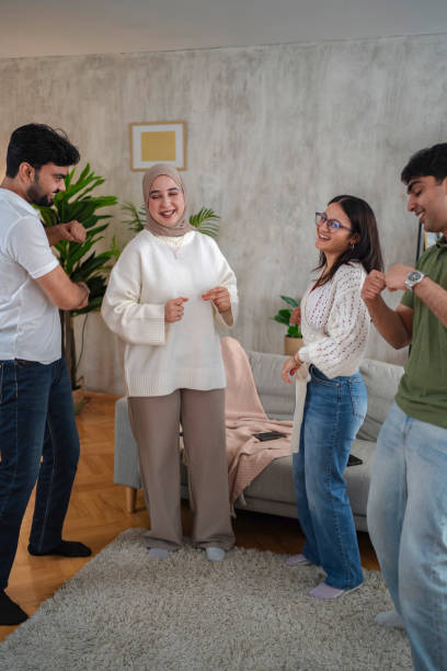 istock Four Young Adults Dancing Together in a Living Room 2200538957