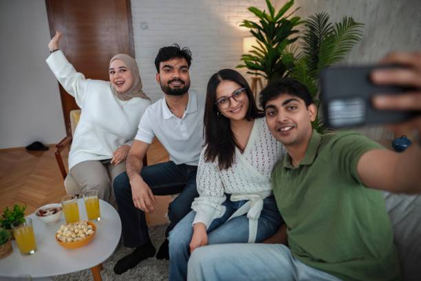 istock Four young adults taking a selfie on the sofa at home 2200539003