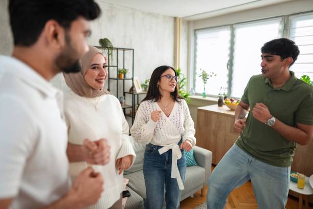 istock Four Young Adults Dancing Together in a Living Room 2200539605