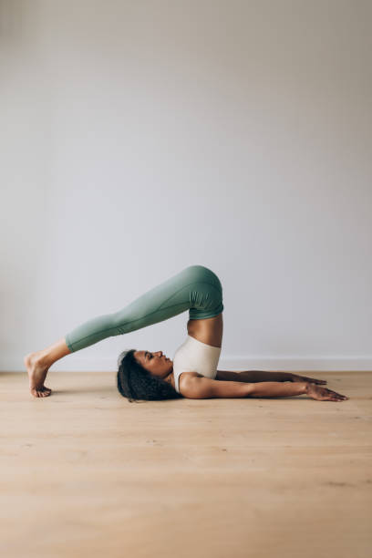 istock Flexible woman performing yoga plow pose indoors 2200540017
