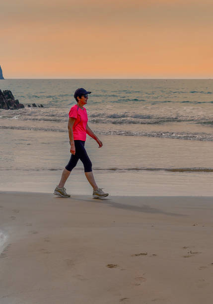 lonely person walking on beach at beautiful red sunset