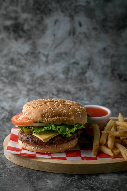 istock Cheeseburger and fries on a wooden board 2200541395