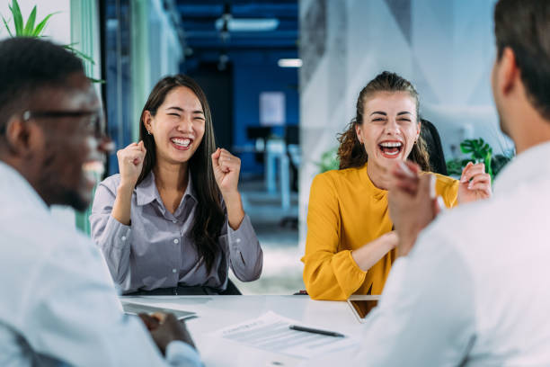 Cheerful entrepreneurs celebrating success in the office.