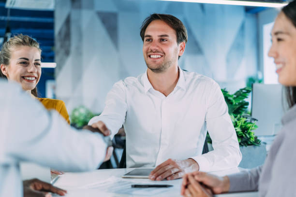 istock Businessmen shaking hands across the table. 2200542756