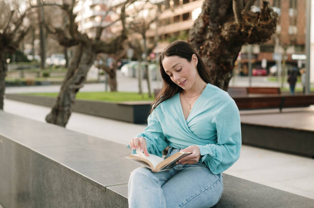 istock Young woman reading outdoors 2200543662