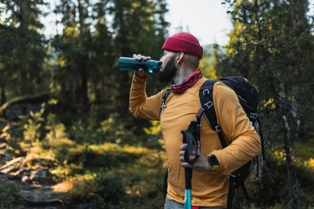 istock Man Hiking Through Forest with Backpack and Water Bottle 2200543754