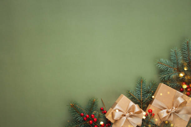 istock Christmas gift boxes with fir branches on green background. 2200545609