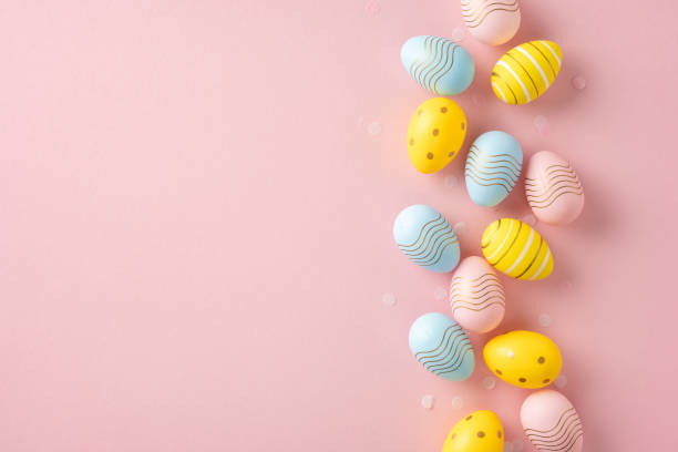 istock Delightful display of decorated pastel-colored Easter eggs aligned against a soft pink backdrop 2200546892