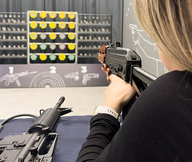 istock Woman aiming pistol at target out indoor firing range or shooting range. 2200547281