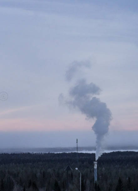 istock Factory chimney emitting smoke at sunset sky. 2200547415
