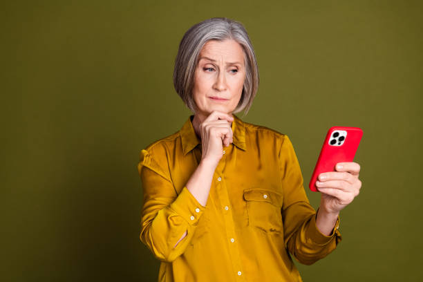 istock Photo of doubtful attractive lady dressed blouse communicating modern device empty space isolated khaki color background 2200548404