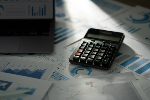 istock A person is using a calculator financial accounting business read report analysis graph data on paperwork management tax 2200548466