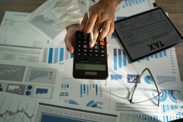 istock Tax calculation is essential in business financial reports and office document analysis, using charts, graphs, and accounting paperwork for data-driven investment concepts. 2200548467