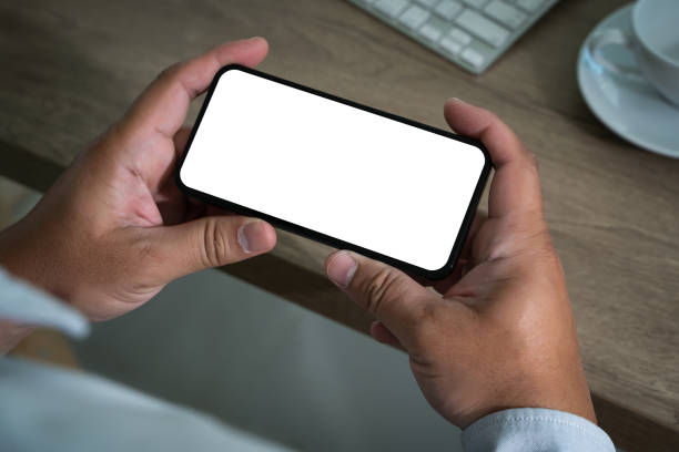 istock A smart person is using a laptop and smartphone at a modern office desk, holding a phone in one hand and typing on a keyboard, displaying digital communication and business with a white screen 2200548489