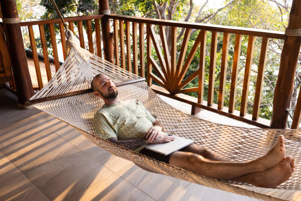istock Relaxed man in hammock with laptop 2200550838