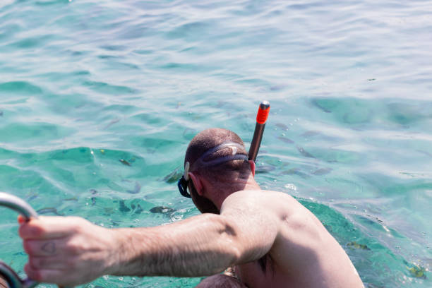Man snorkling in crystal clear water in Thailand