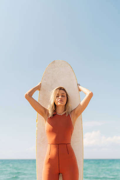 Portrait of a young female surfer and her surfboard